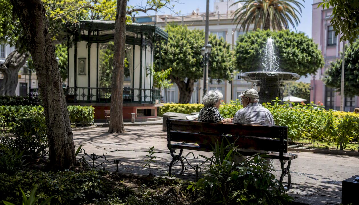 Una pareja pasea tranquilamente por una calle residencial de Santa Cruz.