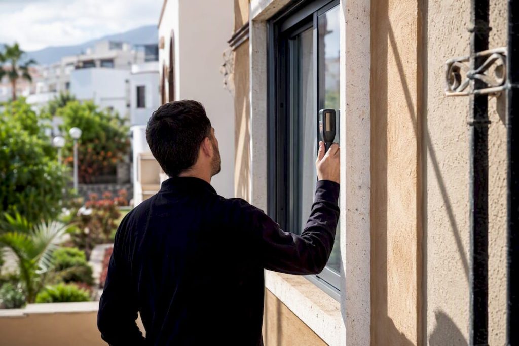 Inspector técnico midiendo las ventanas de una casa