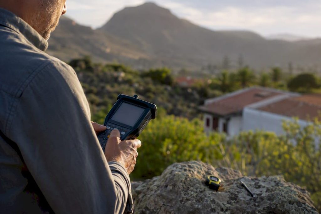 Topógrafo midiendo los límites de una propiedad al aire libre